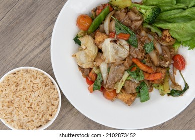 Overhead View Of Pad Kee Mao Authentic Thai Food Served With A Side Order Of Brown Rice For A Complete Meal.