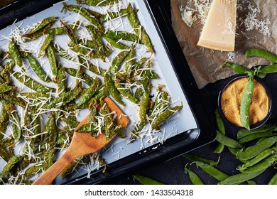 Overhead View Of Parmesan And Cornmeal Breaded Snap Peas Roasted In A Baking Pan. Ingredients On A Concrete Table, View From Above, Flatlay