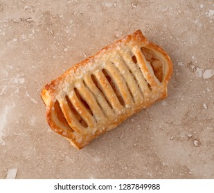 Overhead View Of A Pastry With Apple Filling On A Marble Counter Top.