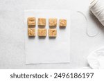 Overhead view of peanut butter fudge on a white marble tray, top view of soft peanut fudge squares on a white background