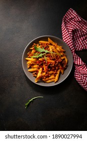 Overhead View Of Penne Pasta With Bolognese Sauce On Dark Surface