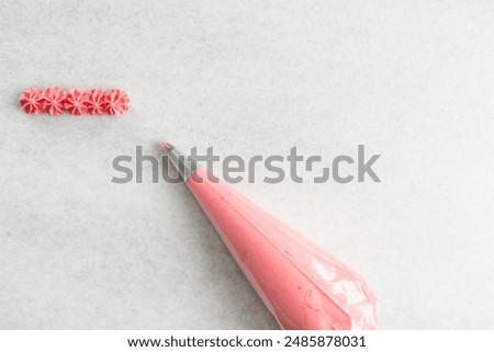 Overhead view of pink buttercream in a piping bag, top view of a pastry bag filled with pink american buttercream