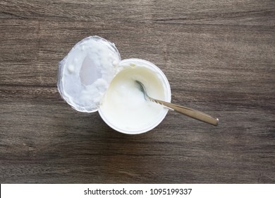 Overhead View Of Plain Or Natural Yoghurt In Yogurt Pot With Dessert Spoon