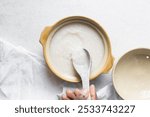 Overhead view of Plain rice congee in a ceramic spoon, top view of thick rice porridge, chinese congee, korean juk or japanese okayu in a spoon