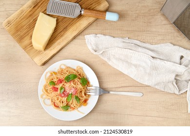 Overhead View Of A Plate With Prepared Spaghetti With Vegetable Sauce And Basil. View From Above At Food On Kitchen Tabletop.