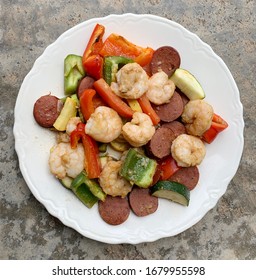 Overhead View Of A Plate With Roasted Cajun Shrimp, Andouille Sausage, Red And Green Peppers, Zucchini And Yellow Squash