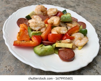 Overhead View Of A Plate With Roasted Cajun Shrimp, Andouille Sausage, Red And Green Peppers, Zucchini And Yellow Squash