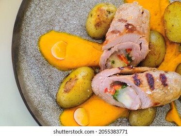 Overhead View At Pork Tenderloin With Carrot Puree, Baby Potatoes Sauteed With Rosemary On Grey Plate