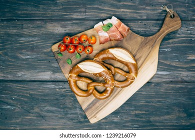 Overhead View Of Pretzel On Wooden Kitchen Board. Dark Background