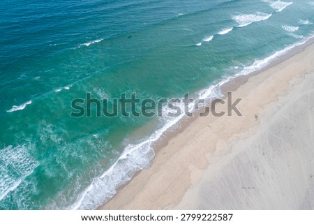 Overhead view of pristine coastline with white sea foam and sand The Concept of eco tourism and sustainability