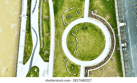 An overhead view of the promenade and multiple pathways and public spaces that are situated next to the river that flows through the center of this city.