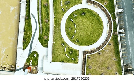 An overhead view of the promenade and multiple pathways and public spaces that are situated next to the river that flows through the center of this city.