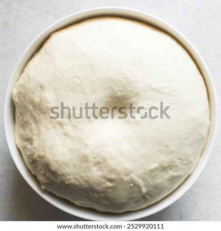 Overhead view of proofed bread dough, Checking if dough is proofed using a finger poke test, process of making bread