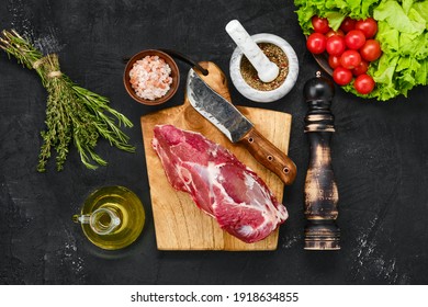 Overhead View Of Raw Lamb Rump On Wooden Cutting Board