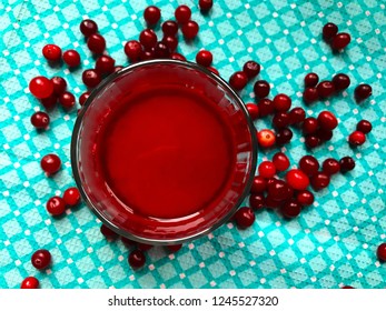 Overhead View Of Red Cranberry Fruit-juice In Glass On Blue-green Pattern Background