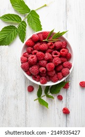 Overhead view of ripe red raspberry on white wood