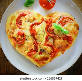 Overhead View Of A Romantic Heart Shaped Italian Pizza Topped With A Vegetarian Topping Of Golden Melted Cheese And Tomato On A Plain White Plate. More Pizza At My Port.