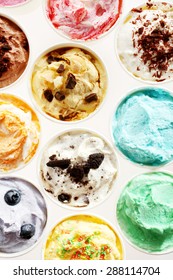Overhead view of rows of individual tubs of colorful Italian ice cream on white with assorted colors and flavors for refreshing summer desserts