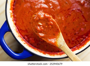 Overhead view of savory marinara, slow cooked all day in an enamel coated cast iron Dutch oven.  - Powered by Shutterstock