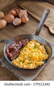 Overhead View Of Scrambled Eggs With Bacon In Frying Pan