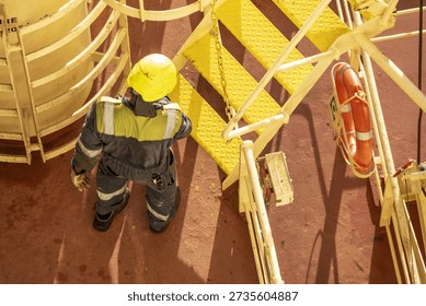 Overhead view of a seafarer performing visual inspection on a ship deck.