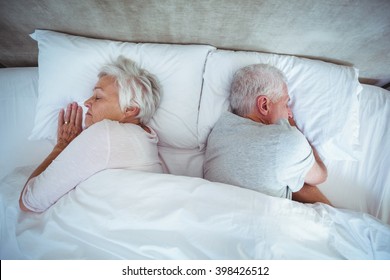 Overhead View Of Senior Couple Sleeping On Bed