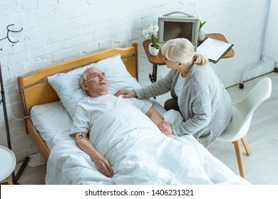 Overhead View Of Senior Woman And Man In Coma In Hospital