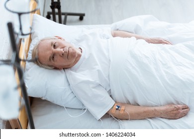 Overhead View Of Sick Senior Man Lying On Bed In Clinic