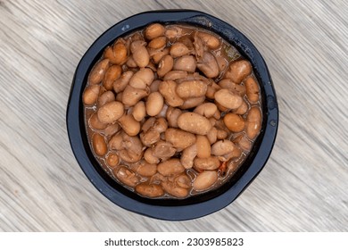 Overhead view of side order of whole pinto beans, slow cooked to perfect softness and served in decorative bowl.