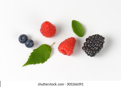 Overhead View Of Single Pieces Of Fresh Wild Berries With Green Leaf