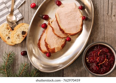 Overhead View Of Sliced  Roasted Turkey With Cranberry Sauce On Wooden Background