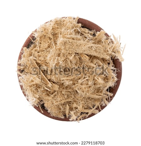 Overhead view of a small bowl filled with shredded slippery elm bark isolated on a white background.