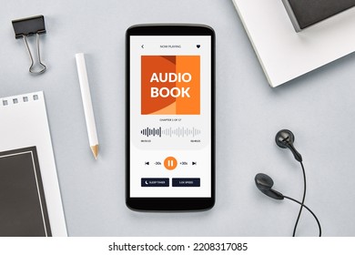 Overhead view of smartphone screen with audio book app open on desk - Shutterstock ID 2208317085