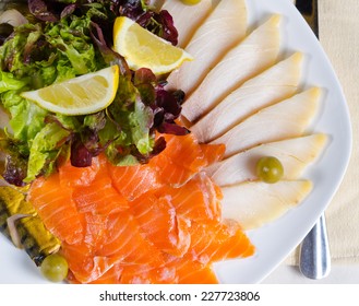 Overhead View Of A Smoked Salmon And Cheese Platter Served With Fresh Lettuce And Garnished With Lemon Wedges