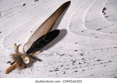 Overhead view of a smudging feather for incense rituals for purification and new energy on white old wood background - Shutterstock ID 2349166103
