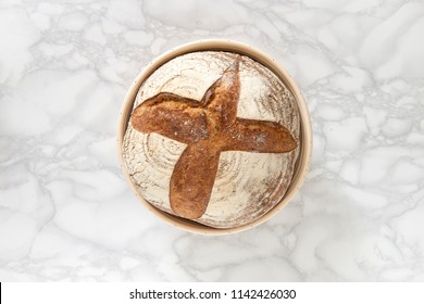 Overhead View Of A Sourdough Bread In Bowl On Marble Background