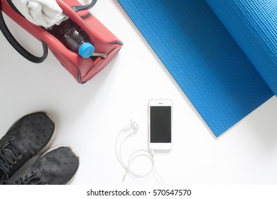 Overhead View Of Sport Equipment And Smartphone On Blue Yoga Mat On White Background, Isolated On White With Copy Sapce