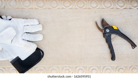 Overhead View Of Stone Bench With White Garden Gloves, Clippers And A Yellow Rose