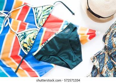 Overhead View Of Summer Concept With Bikini, Colorful Beach Umbrella And Girls Accessories