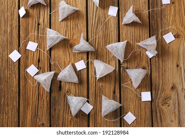 overhead view of tea bags with strings and labels, on the wooden table