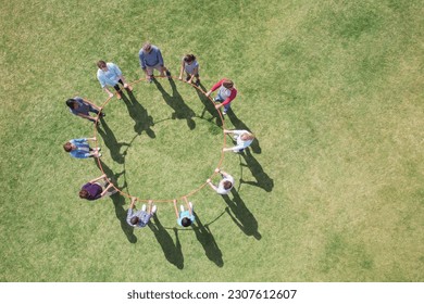 Overhead view of team connected in circle around plastic hoop - Powered by Shutterstock