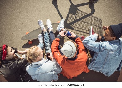 Overhead View Of Teenagers Group Sitting Together And Talking At Skatepark