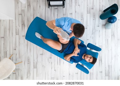 Overhead view of a Therapist Assisting Male Patient While Stretching His Leg In Hospital. High quality photo - Powered by Shutterstock