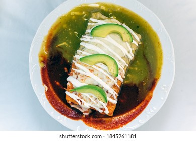 Overhead View Of Three Colored Wet Burrito Served In Red And Green Sauce, Looks And Tastes Appealing.