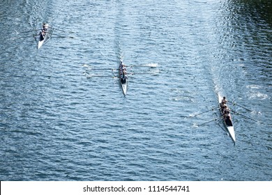 Overhead View Of Three Four-person Crew Teams Racing Rowing Shells On A Calm Lake