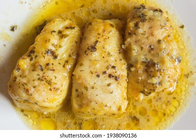 Overhead View Of Three Tasty Hake Loins In Green Sauce On A White Plate. Fish And Healthy Food.