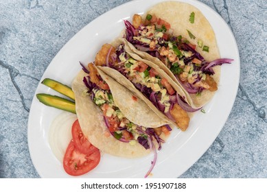 Overhead View Of Threesome Of Tempting Fish Tacos Loaded With All The Fillings To Satisfy Any Appetite For Mexican Food.