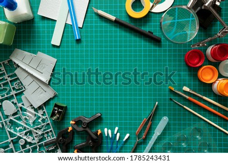 Overhead View Of Tools And Materials For Building Scale Model Aeroplane From Kit On Cutting Board