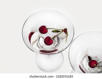 An Overhead View Of Two Cherries In Dry Martini On A White Background