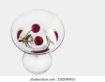 An Overhead View Of Two Cherries In Dry Martini On A White Background